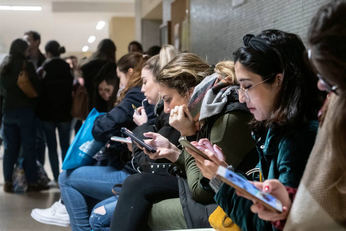 Aspirantes EIR revisando sus teléfonos móviles horas antes del examen (Fotos: José Luis Pindado)
